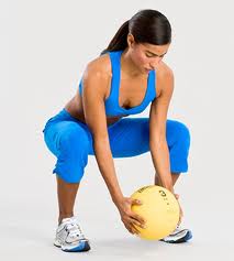 Woman squatting with workout ball